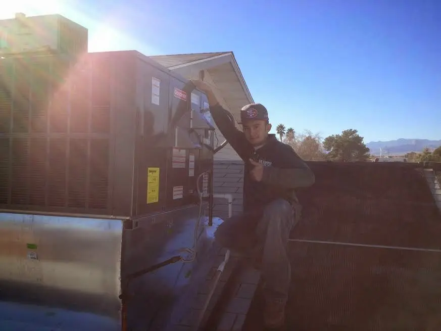 HVAC technician performing AC Tune-Up on a rooftop unit in Beckley